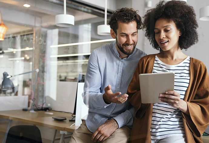 homem e mulher num escritório, a conversar e a olhar para um extrato