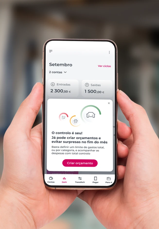Telemóvel com um ecrã da App Millennium da área Gerir, com o texto "O controlo é seu! Já pode criar orçamentos e evitar surpresas no fim do mês" e o botão "Criar orçamento"