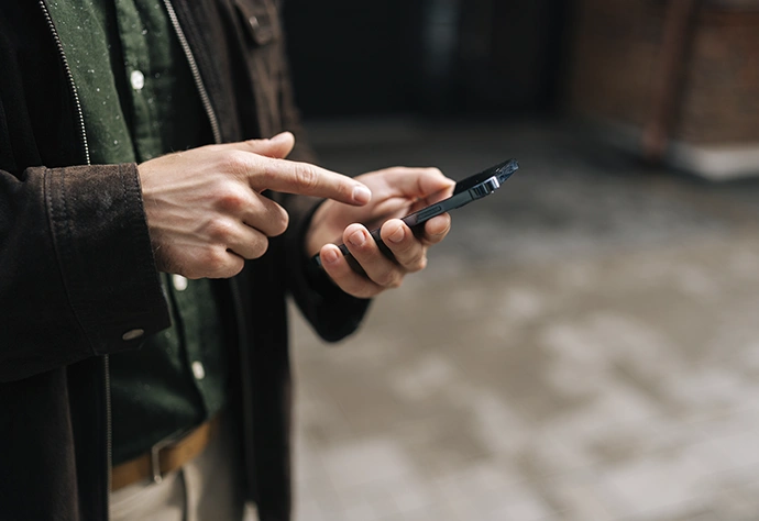 A man's hands using a smartphone to perform an operation