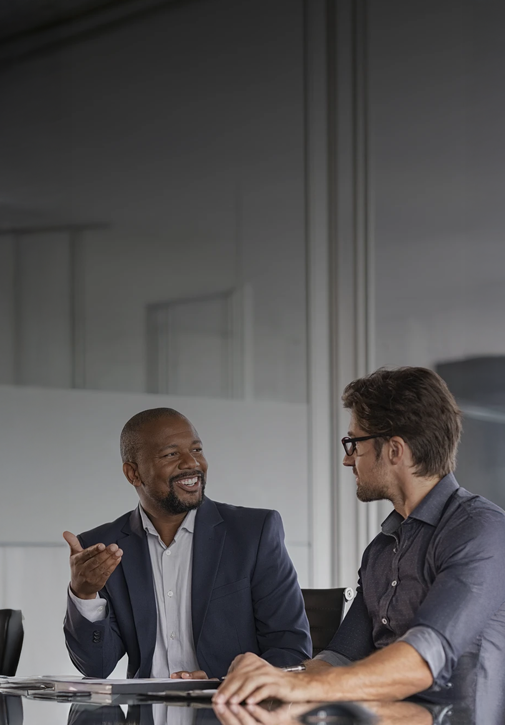 2 homens a conversar numa sala de reuniões