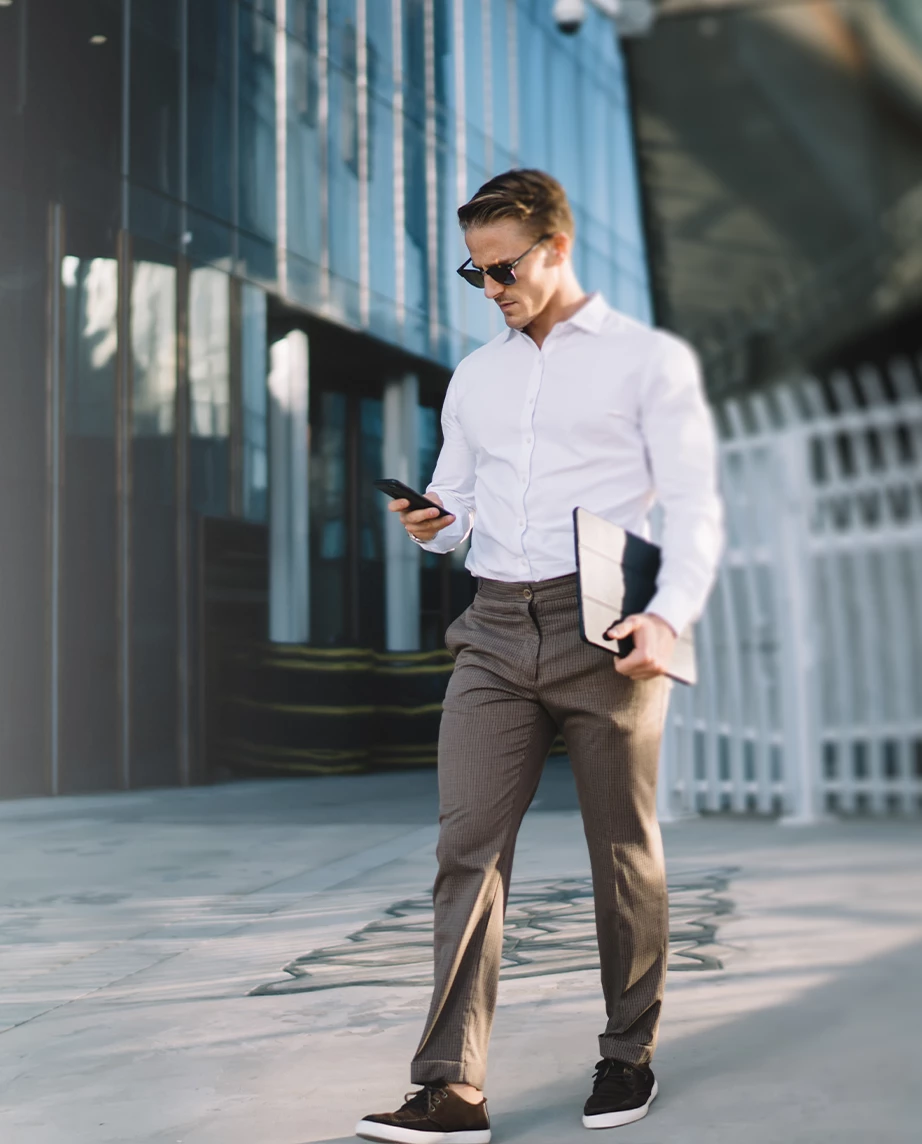 man in a suit, standing, looking at phone