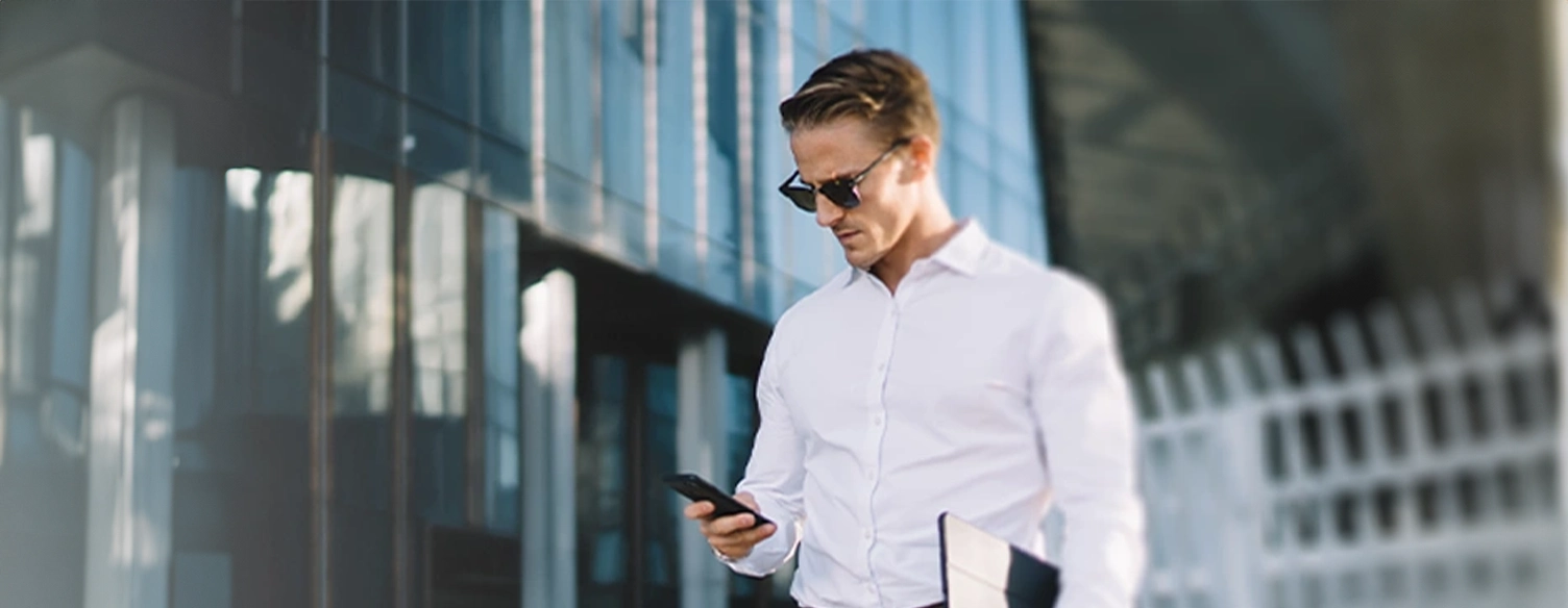 man in a suit, standing, looking at phone