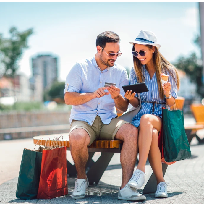 Casal sentado num banco a fazer um pagamento online