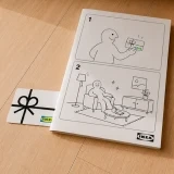Cartão oferta e manual de instruções IKEA no chão de uma sala
