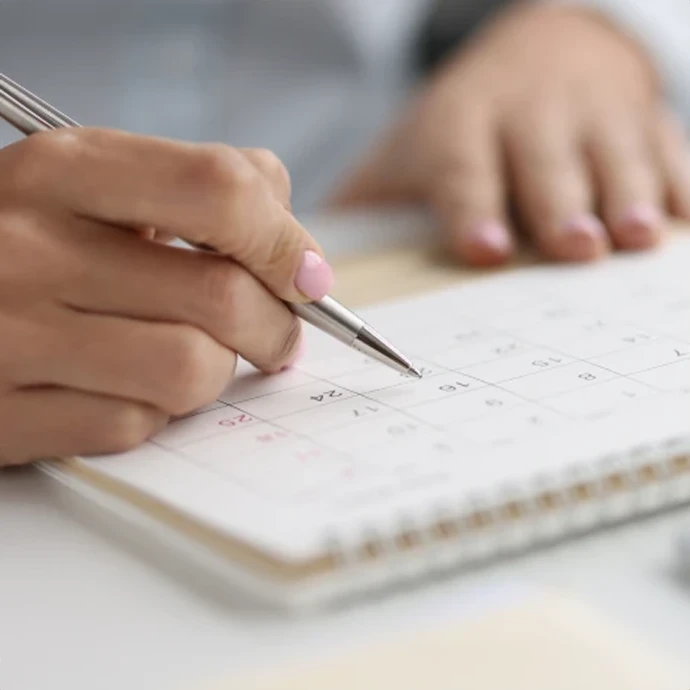 pormenor de mãos a escrever numa agenda