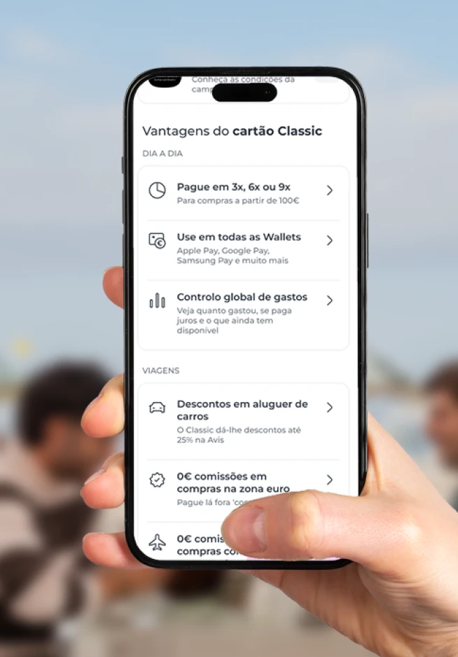 Mão a segurar um smartphone que mostra o ecrã da App Millennium com as vantagens do cartão Classic