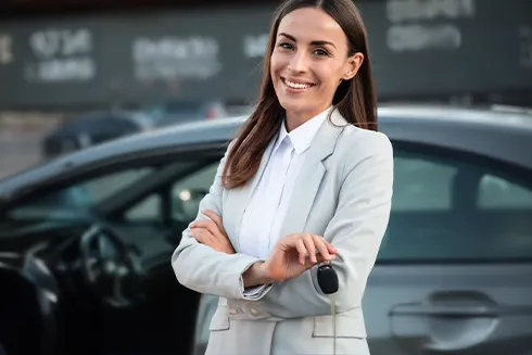senhora sorridente com chave de carro na mão