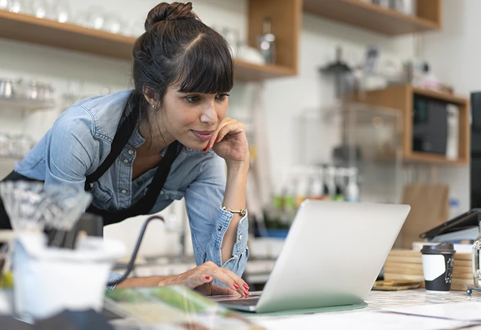 senhora atrás de balcão de café, com computador