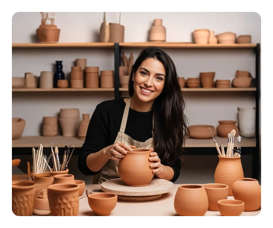 Rapariga a sorrir enquanto faz uma peça de barro