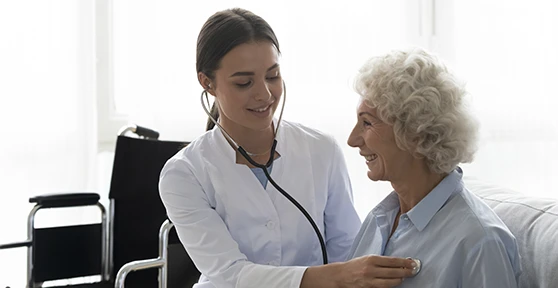 médica a auscultar paciente sénior