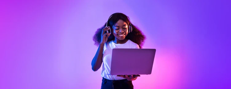 Menina a ouvir música com o computador na mão
