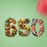 O número 650 formado por diferentes tipos de alimentos sobre um fundo verde