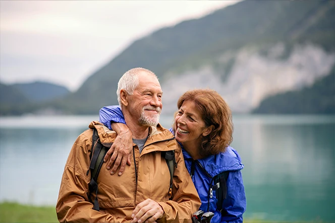 casal maduro a passear junto a lago e montanha