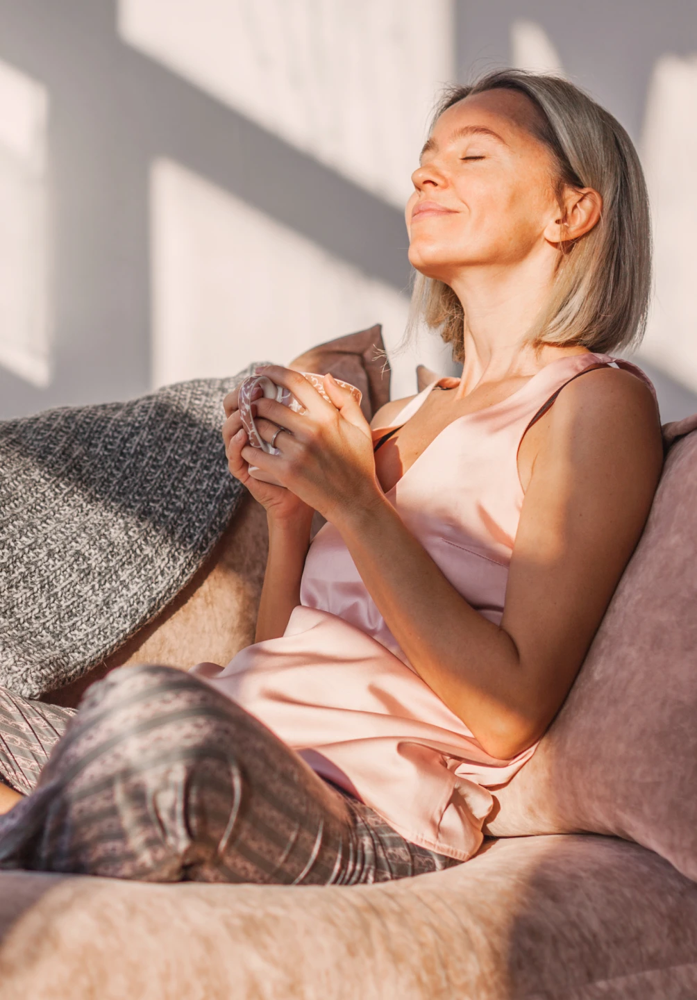 senhora no sofá, a relaxar, com chávena na mão