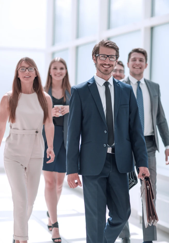 Equipa de 5 pessoas a andar no corredor do seu trabalho