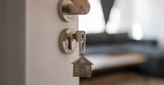  Chave com porta-chaves de casa na fechadura de uma porta entreaberta