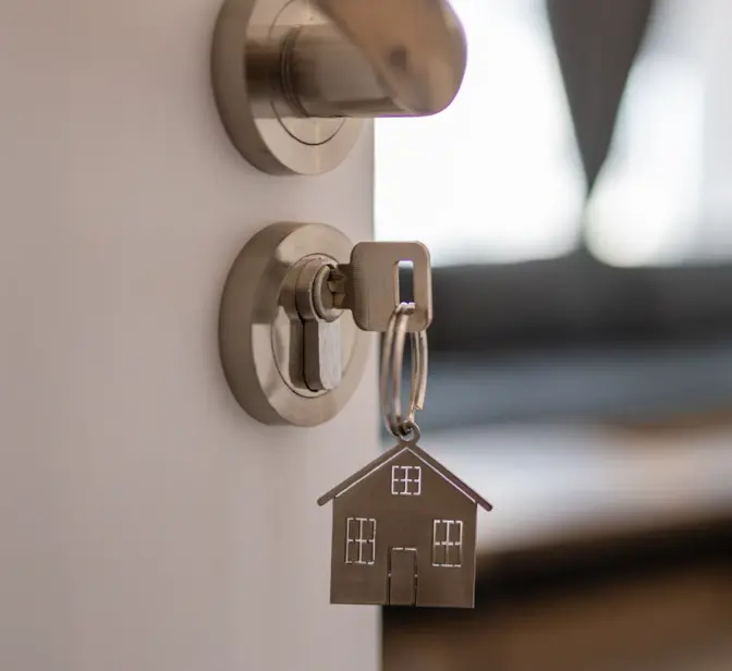  Chave com porta-chaves de casa na fechadura de uma porta entreaberta