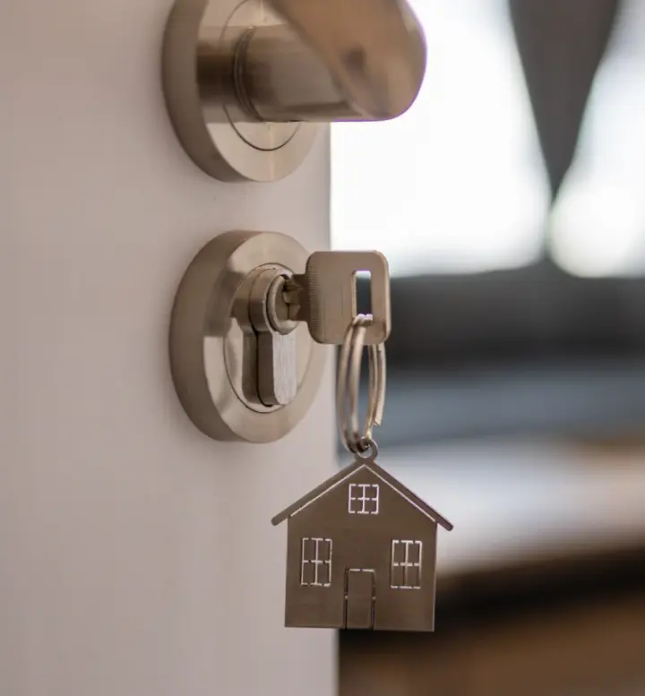  Chave com porta-chaves de casa na fechadura de uma porta entreaberta