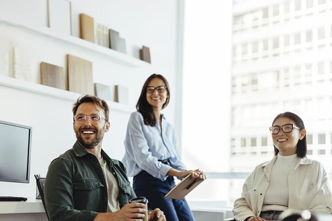 3 people in a meeting in a sunny office