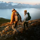 Casal a passear nas montanhas e com vista para um grande lago
