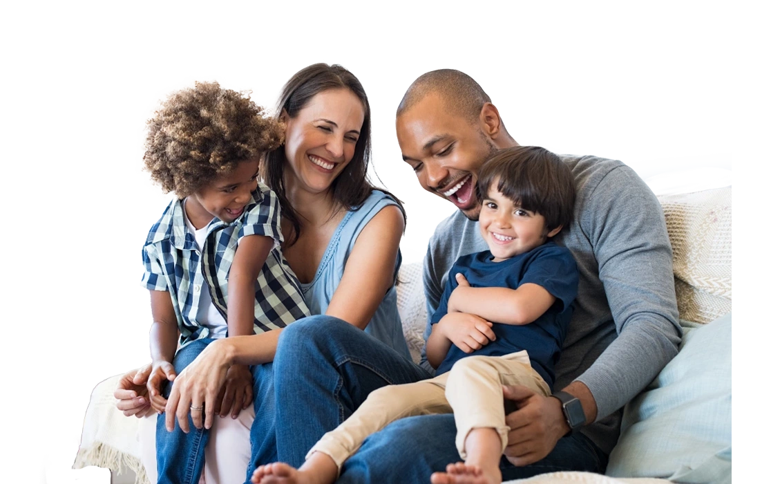 father, mother, and 2 children, sitting on the sofa, smiling