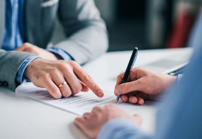 mãos a assinar um contrato