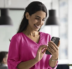 senhora sorridente com telemóvel na mão