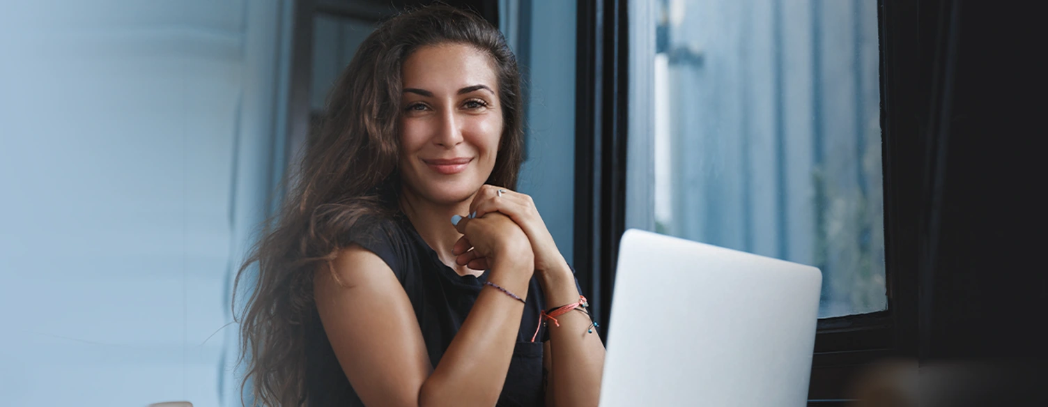 mulher sorridente, em frente a computador