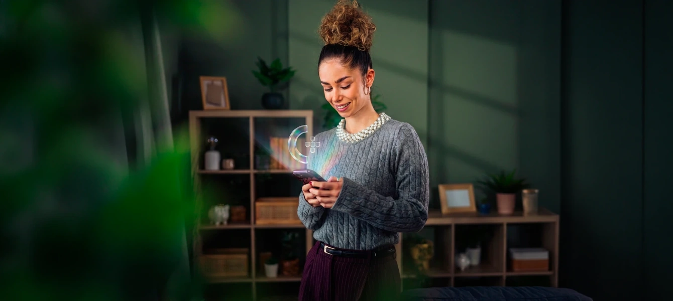 Mulher com telemóvel de onde sai o ícone da Chave Móvel Digital