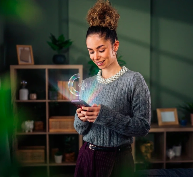 Mulher com telemóvel de onde sai o ícone da Chave Móvel Digital
