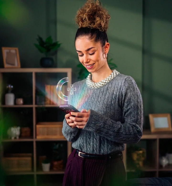 Mulher com telemóvel de onde sai o ícone da Chave Móvel Digital