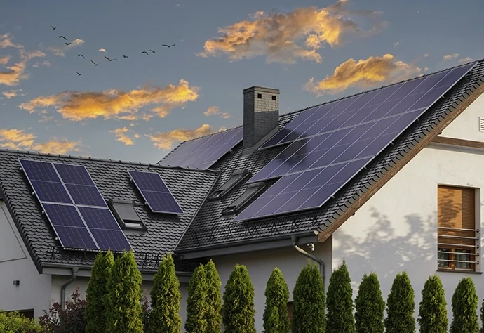Painéis solares instalados no telhado de uma moradia ao pôr do sol