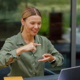 Senhora a comunicar em linguagem gestual pelo seu computador portátil