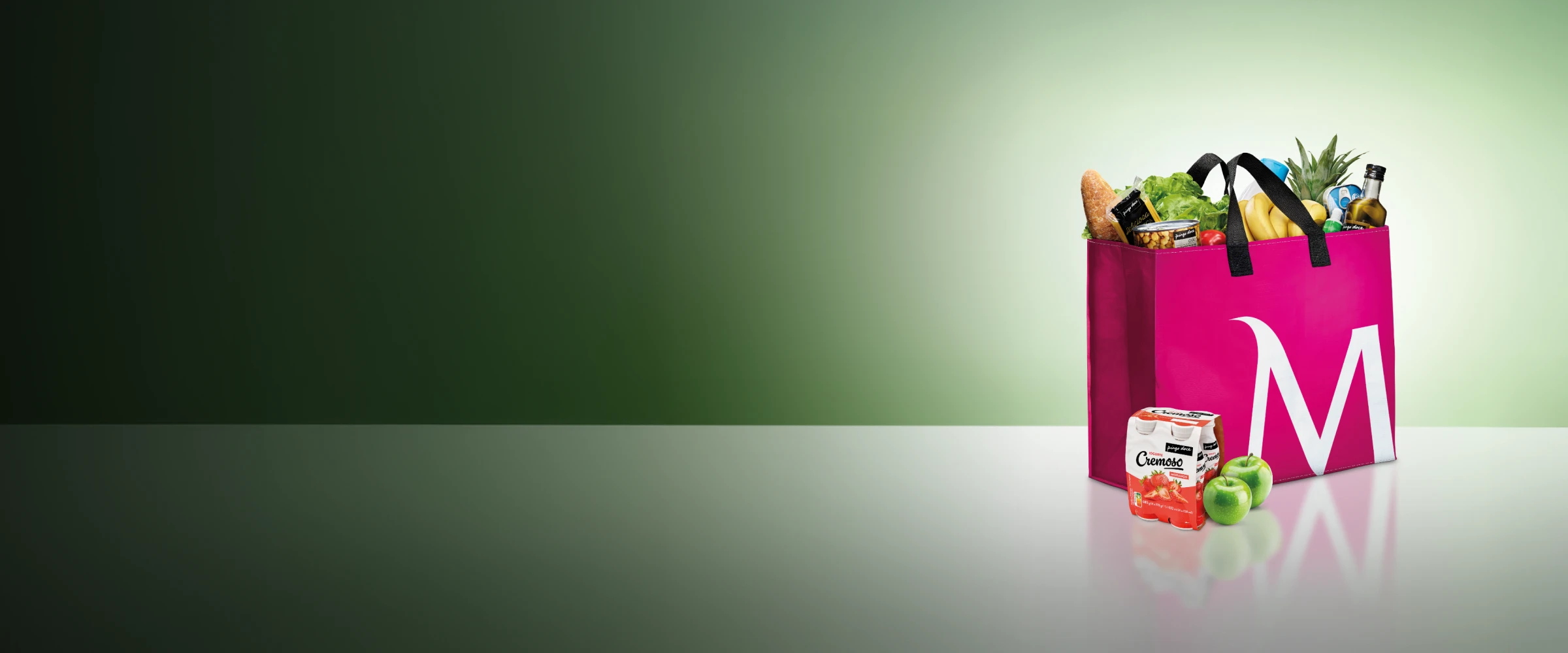 Saco de compras cerise, com o "M" de Millennium bcp desenhado, cheio de fruta, legumes e outra comida