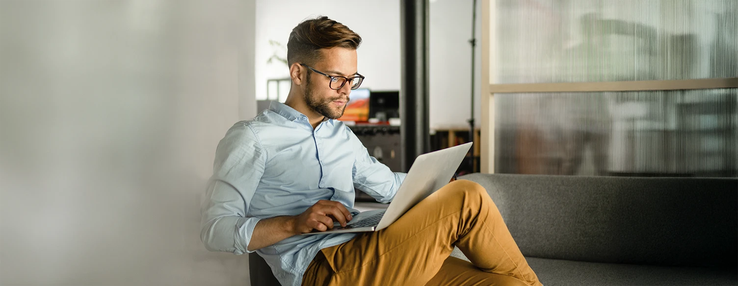 homem sentado num sofá, com computador