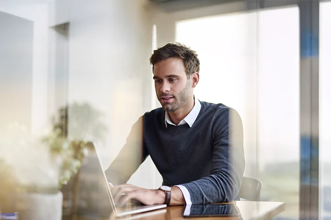 Man sitting in an office, working on a computer