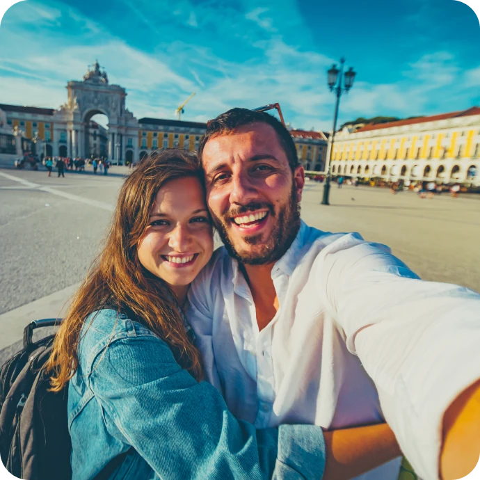 casal sorridente a fazer uma "selfie" em viagem