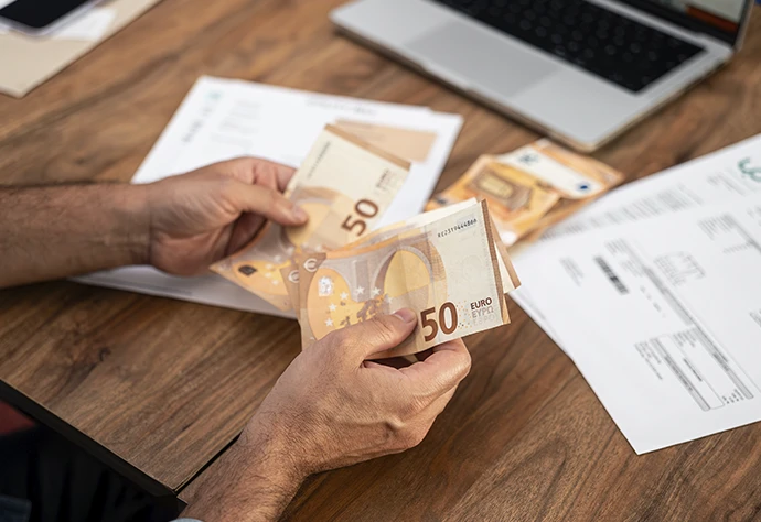 pormenor de mãos a segurar notas de 50 euros