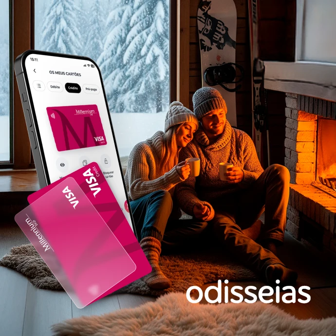 casal sentado em frente a lareira, numa sala com janela com vista para bosque coberto de neve