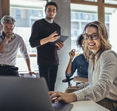 4 pessoas sorridentes, numa sala de reuniões
