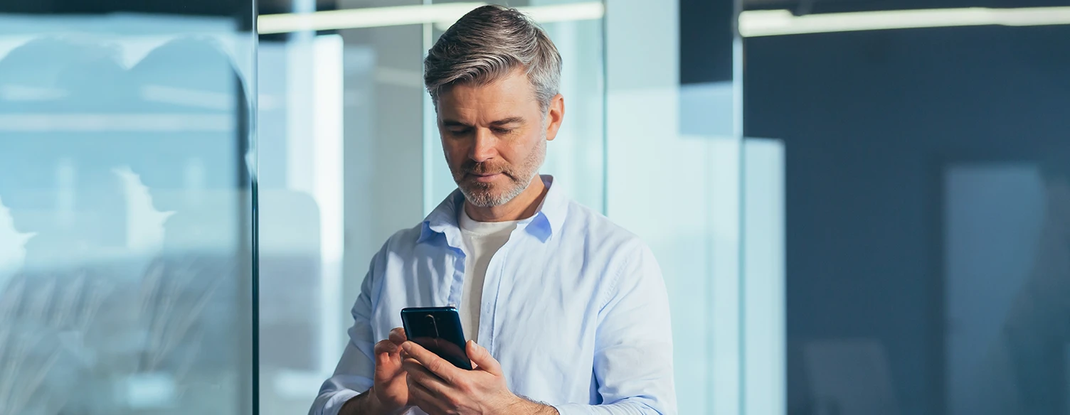 Homem a olhar para o telemóvel na mão