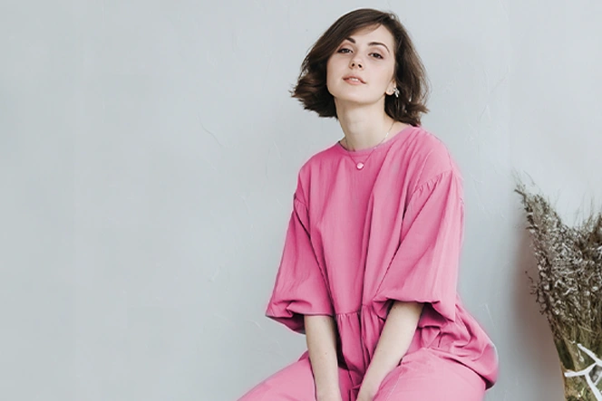 lady dressed in pink, sitting and smiling