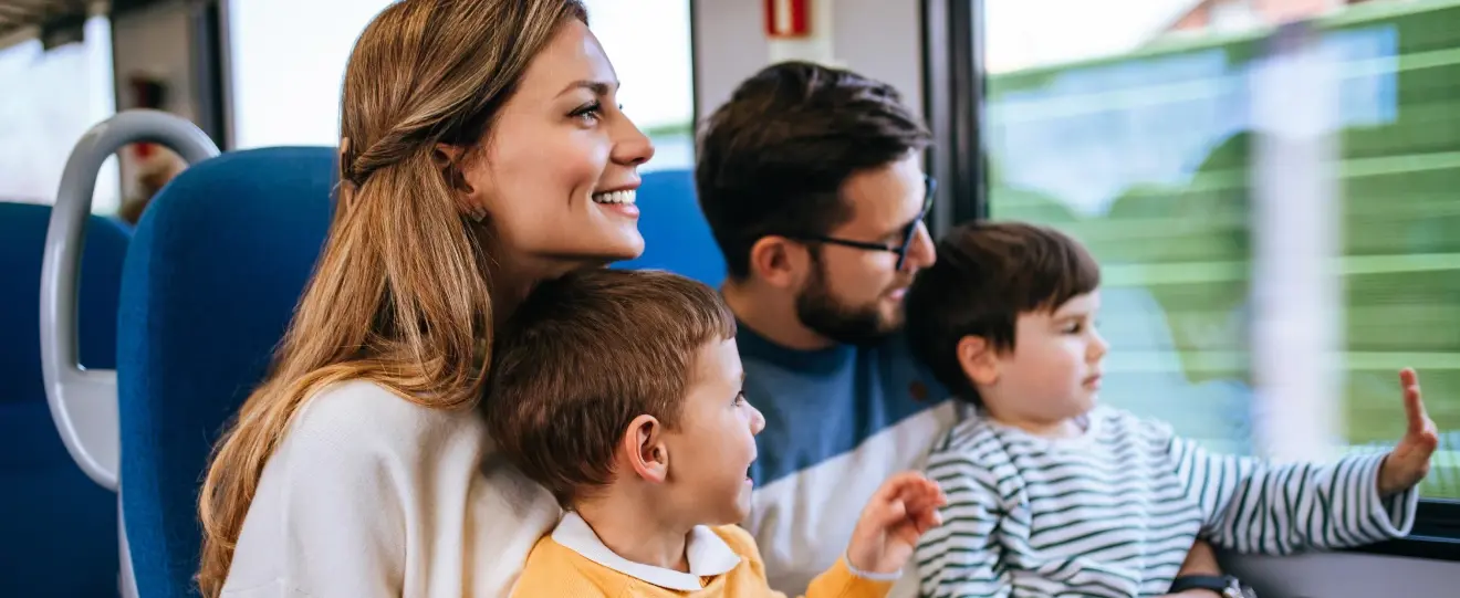 Família com dois filhos a viajar de comboio e a olhar pela janela