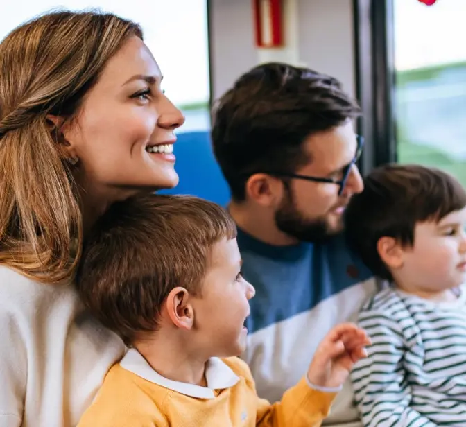 Família com dois filhos a viajar de comboio e a olhar pela janela