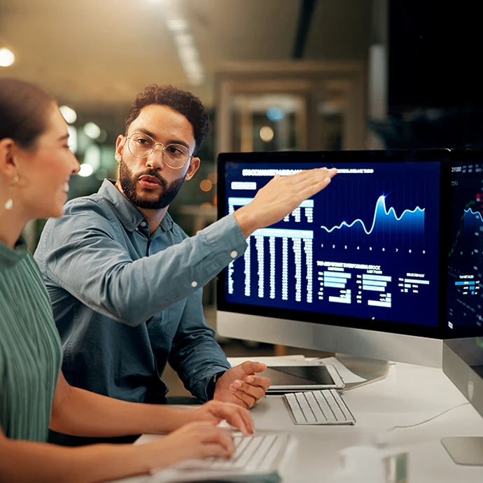 jovem rapaz a dar explicação a colega sobre investimentos, no local de trabalho