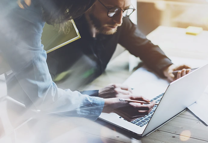 2 pessoas de volta de um computador, a introduzir dados