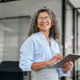 woman in an office, holding a tablet