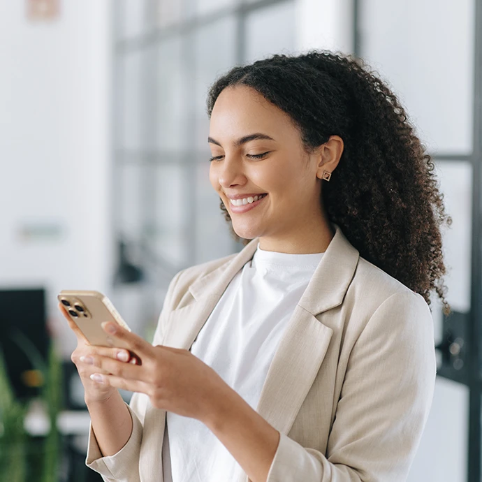 Smiling woman writing on her mobile phone
