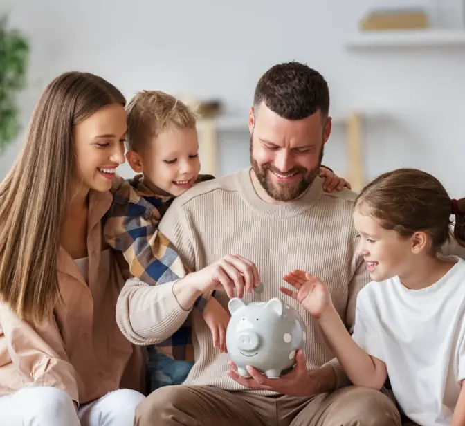 Família a colocar moedas num mealheiro cinzento no sofá