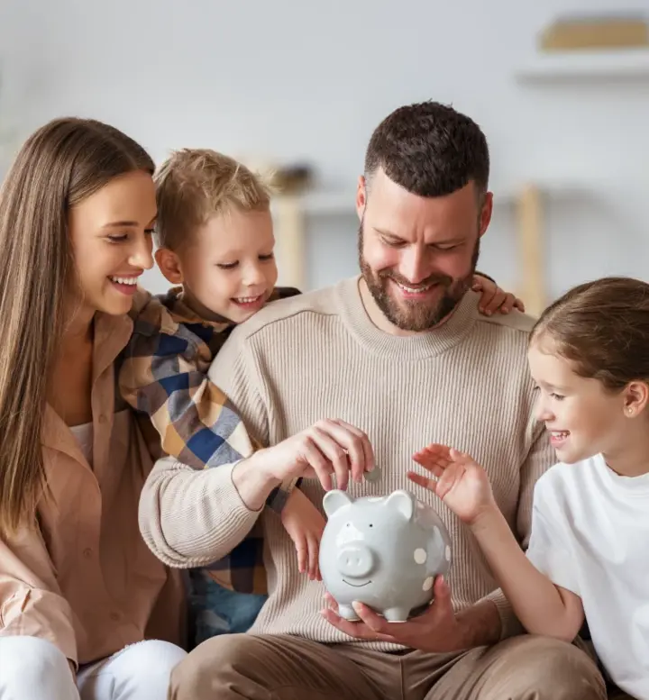 Família a colocar moedas num mealheiro cinzento no sofá